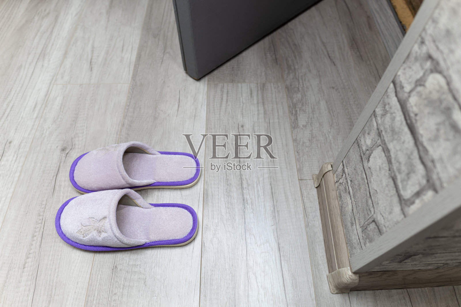 家庭拖鞋站在房子的门槛附近。照片摄影图片