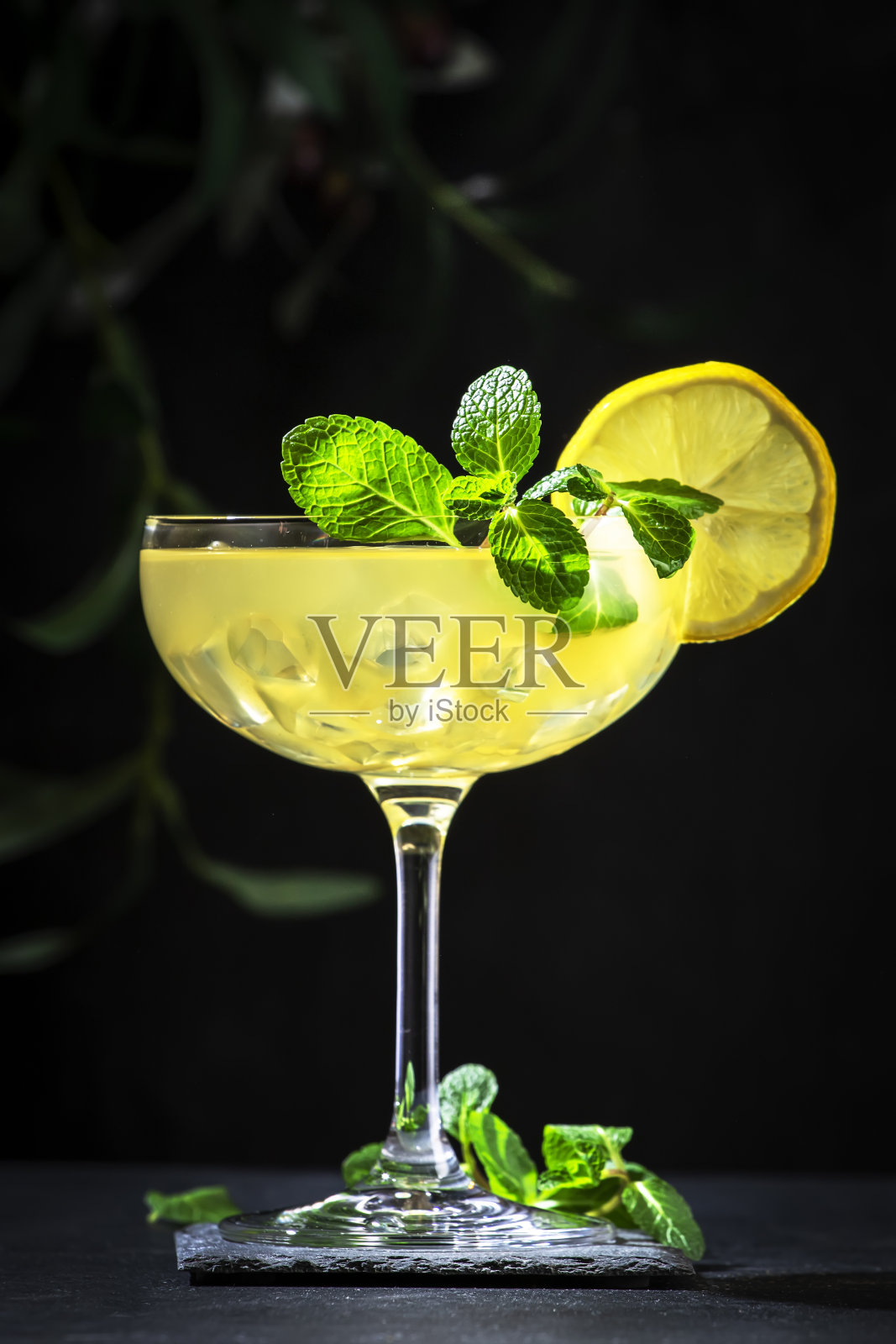 用干杜松子酒、烈酒、柠檬汁和冰块调制的白女士鸡尾酒。黑色背景照片摄影图片