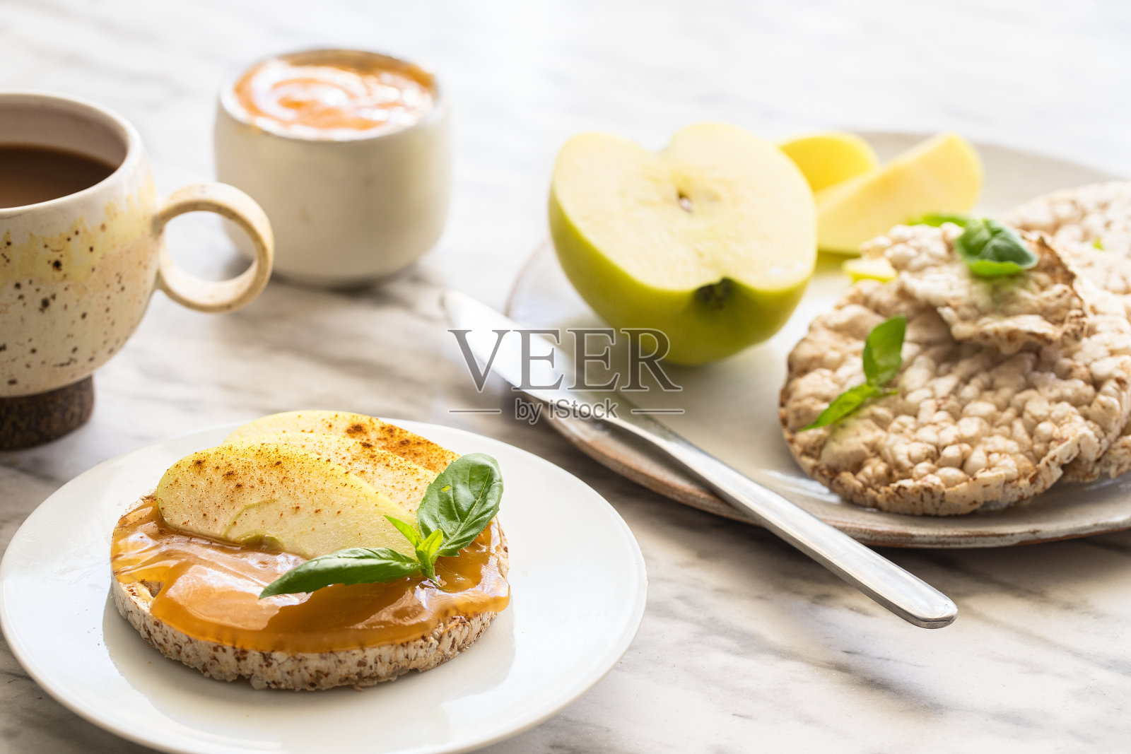 酥脆的荞麦和米饭零食，杏仁黄油和苹果在桌子上。健康甜蜜的早餐照片摄影图片