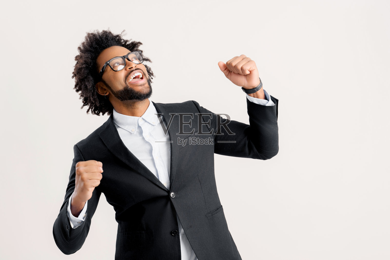 欣喜若狂，兴奋的非裔美国男性企业家，经理或企业主在智能休闲黑色西装大喊“是”照片摄影图片