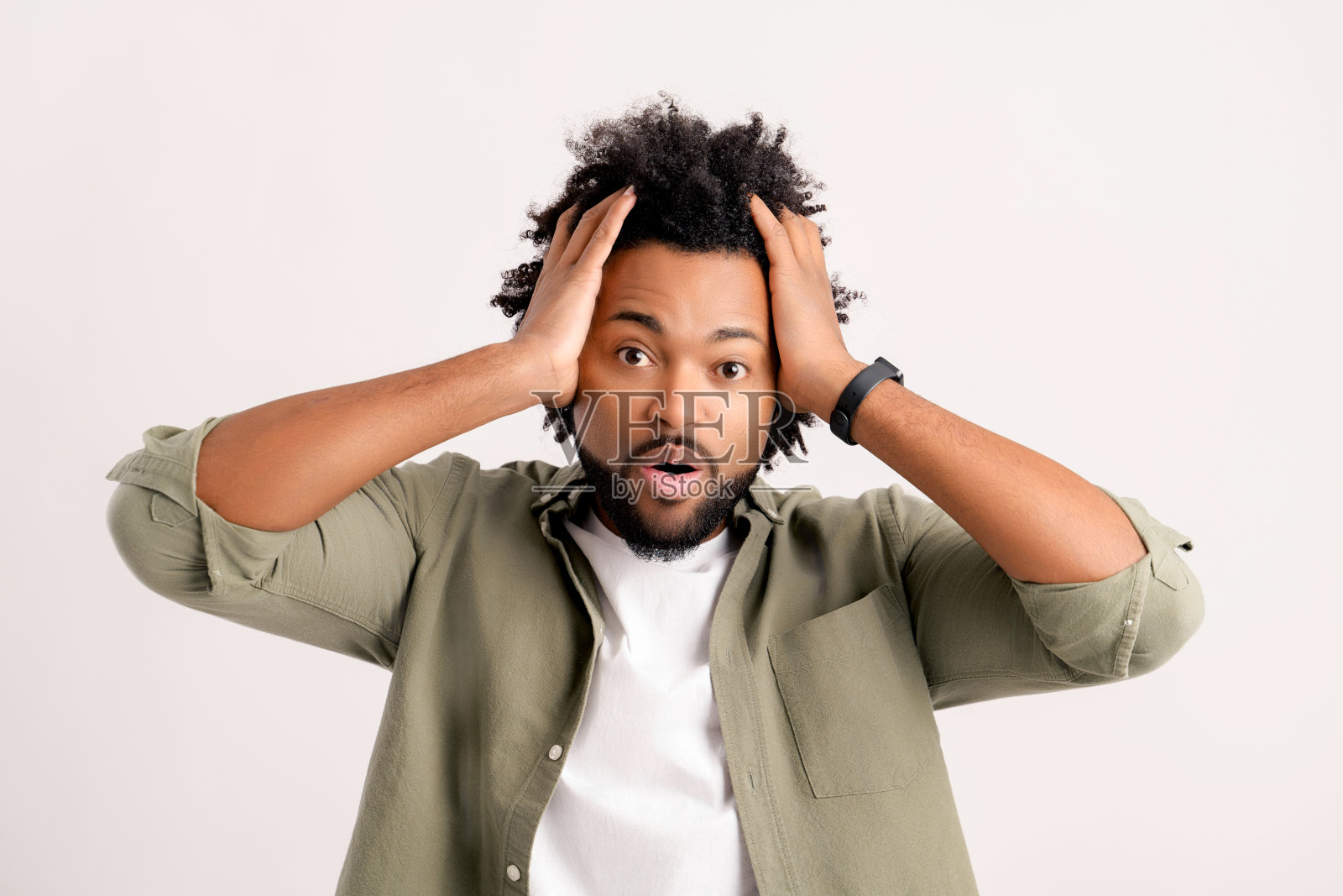 一名惊恐的非洲裔青年睁大眼睛盯着摄像机，眼睛被白色的背景隔开照片摄影图片