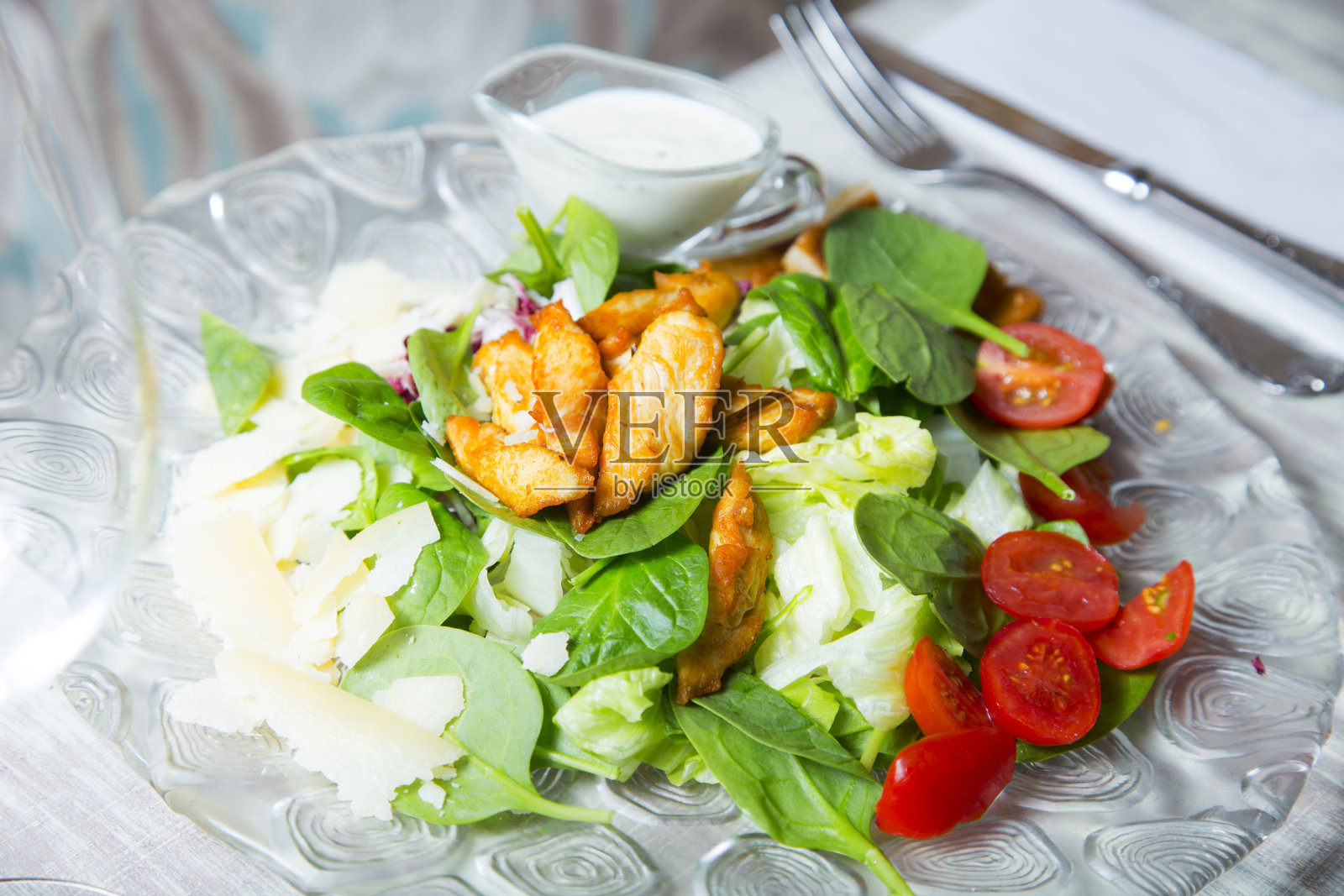 凯撒沙拉是由长叶莴苣、面包丁、鸡肉、柠檬汁、橄榄油、鸡蛋、伍斯特沙司、凤尾鱼、大蒜、第戎芥末、帕玛森奶酪和黑胡椒制成的沙拉。照片摄影图片