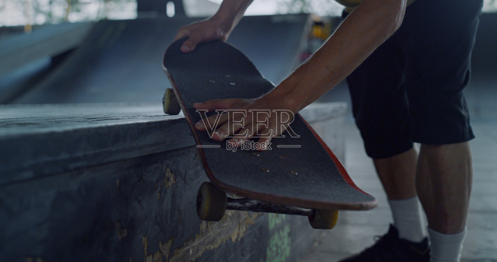 在滑板公园，滑板手握滑板板。男子手持滑板。照片摄影图片