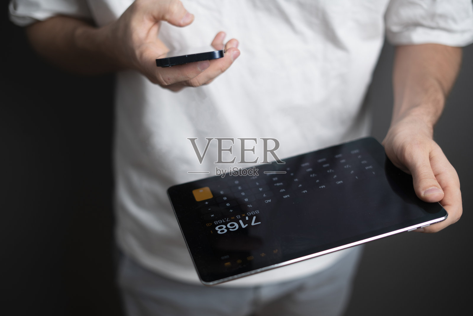 手持平板电脑并使用计算器的人照片摄影图片