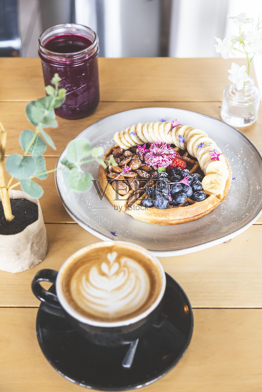 华夫饼配杏仁、蓝莓、草莓、香蕉、蜂蜜和一杯黑咖啡照片摄影图片