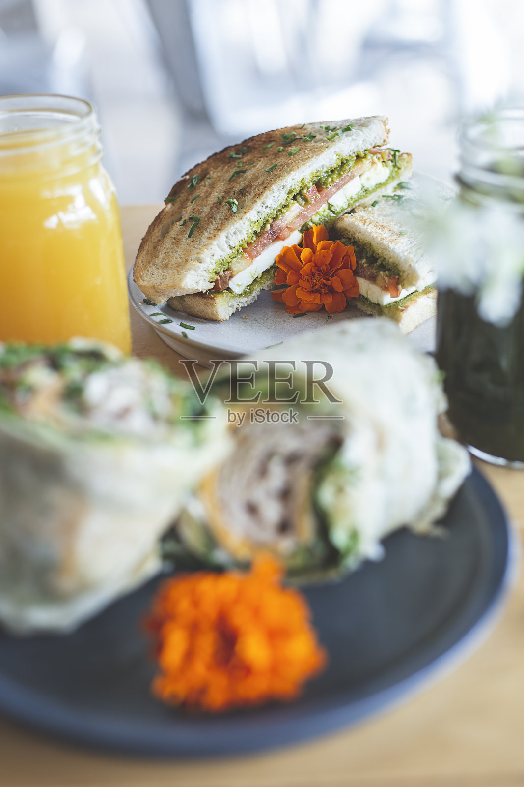 从中间切开，裹上生菜、番茄、奶酪、鳄梨和火腿照片摄影图片