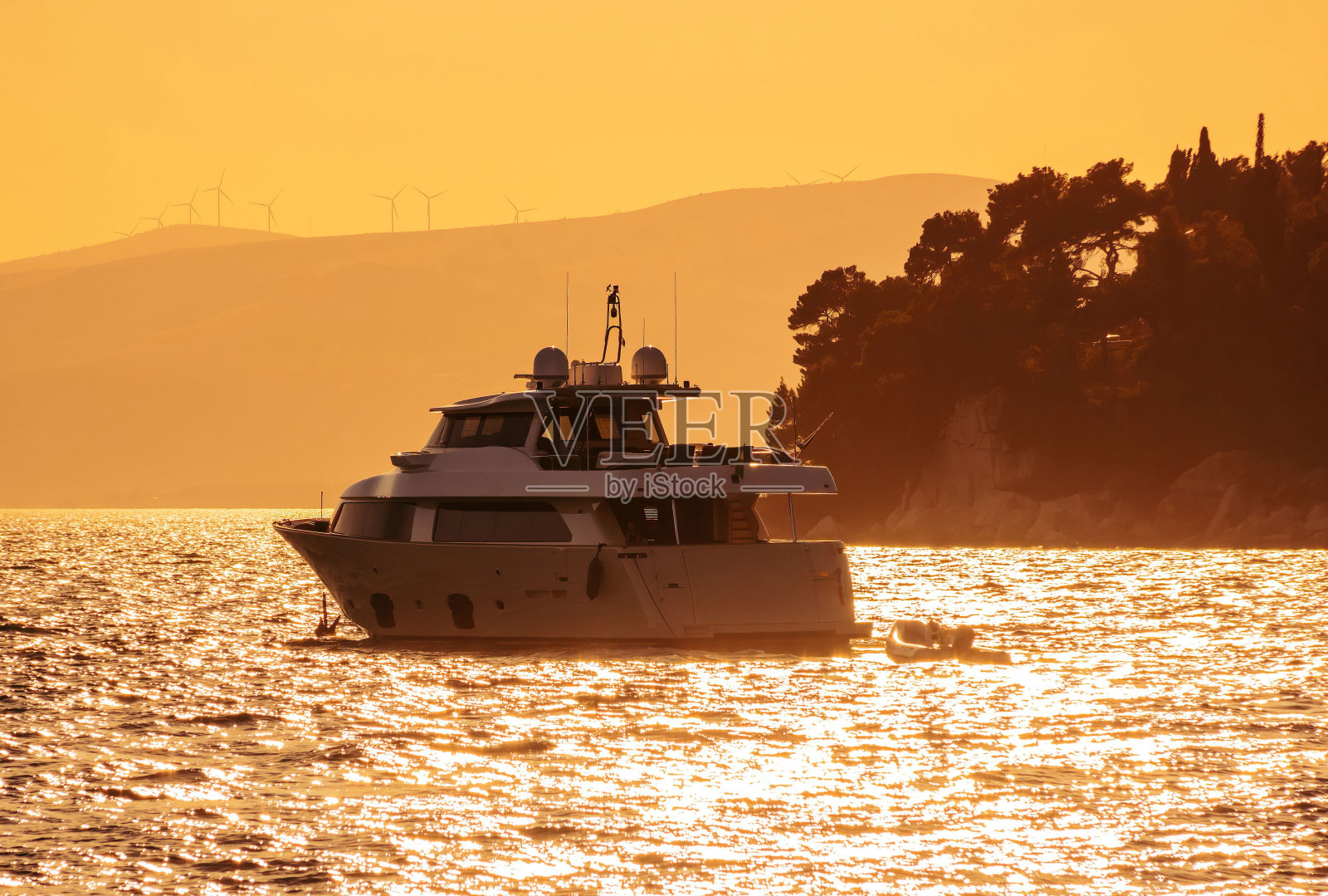 背景中有一艘船在水面上，靠近一些山照片摄影图片