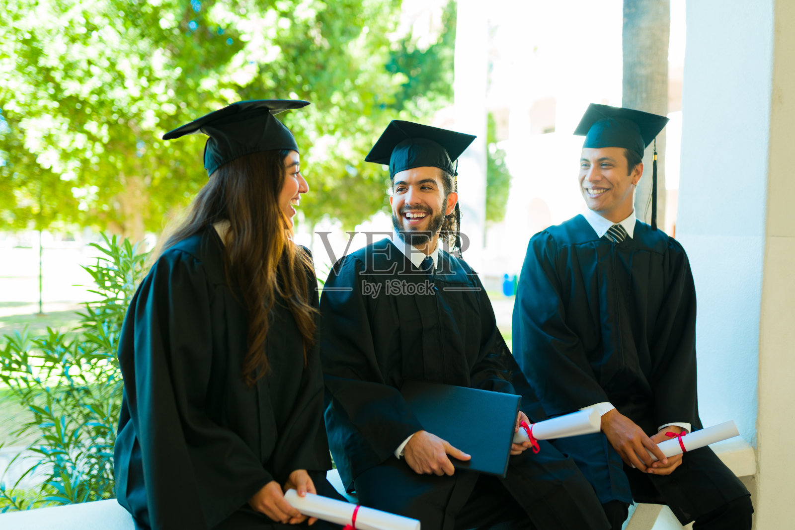 毕业典礼后，兴奋的朋友们谈笑风生照片摄影图片