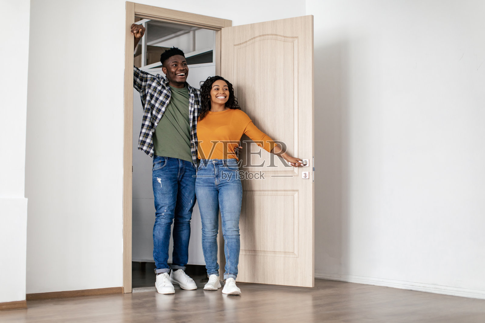 黑人夫妇在新房子敞开的门上拥抱照片摄影图片