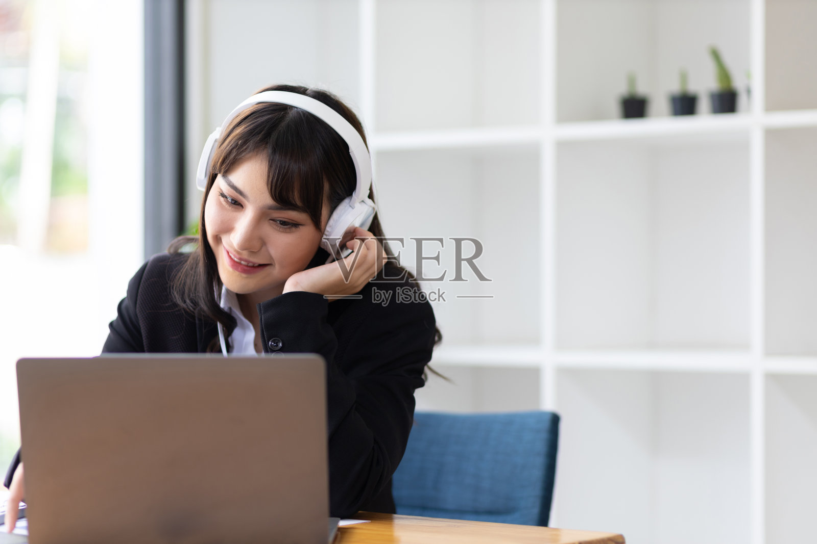 年轻迷人的亚洲商业女性在休息时间听音乐和玩的放松工作。照片摄影图片