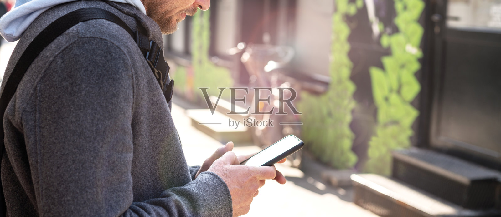 手机在男人手里，网上短信的生活方式。照片摄影图片