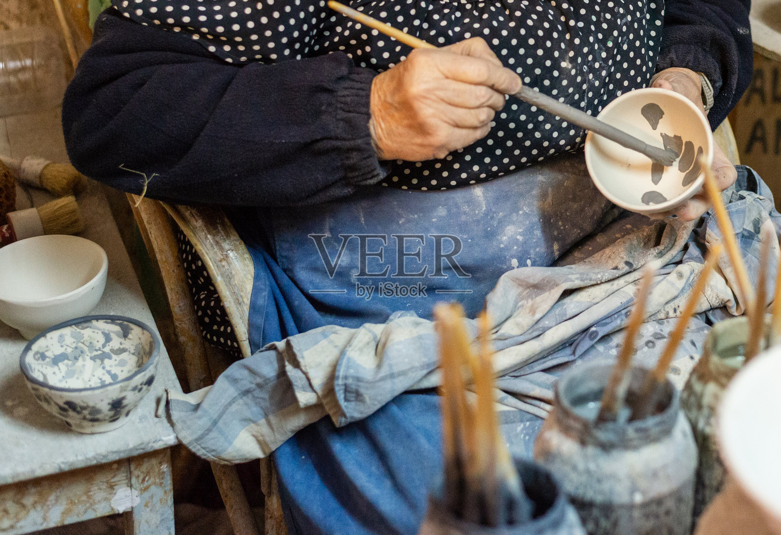 手工制作:一位老妇人正在用陶器制作陶制器皿照片摄影图片