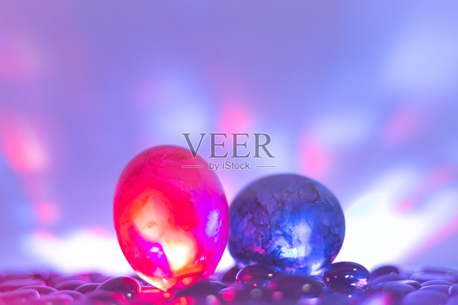 复活节彩蛋在彩色背景的黑色石头上。霓虹灯的效果。前视图。最小的概念。照片摄影图片