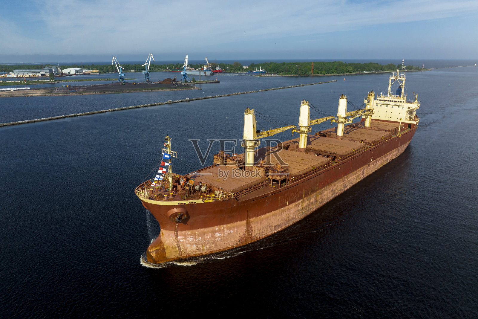 在阳光明媚的夏日，海上的大型空货船照片摄影图片