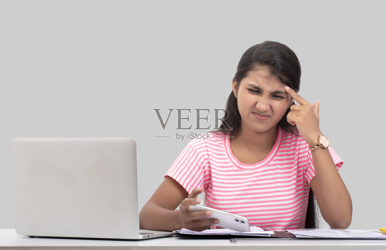 年轻女子在笔记本电脑上工作的肖像，看起来很紧张照片摄影图片