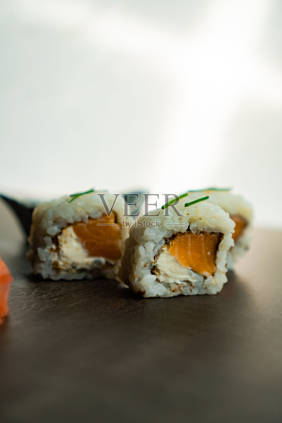 3块寿司，配酱油和姜。白底黑桌寿司。照片摄影图片