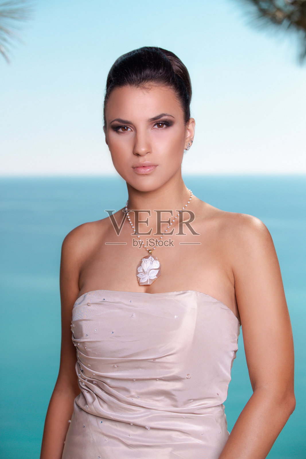 美丽的黑发的肖像穿着裸粉色无肩带上衣，看着相机照片摄影图片