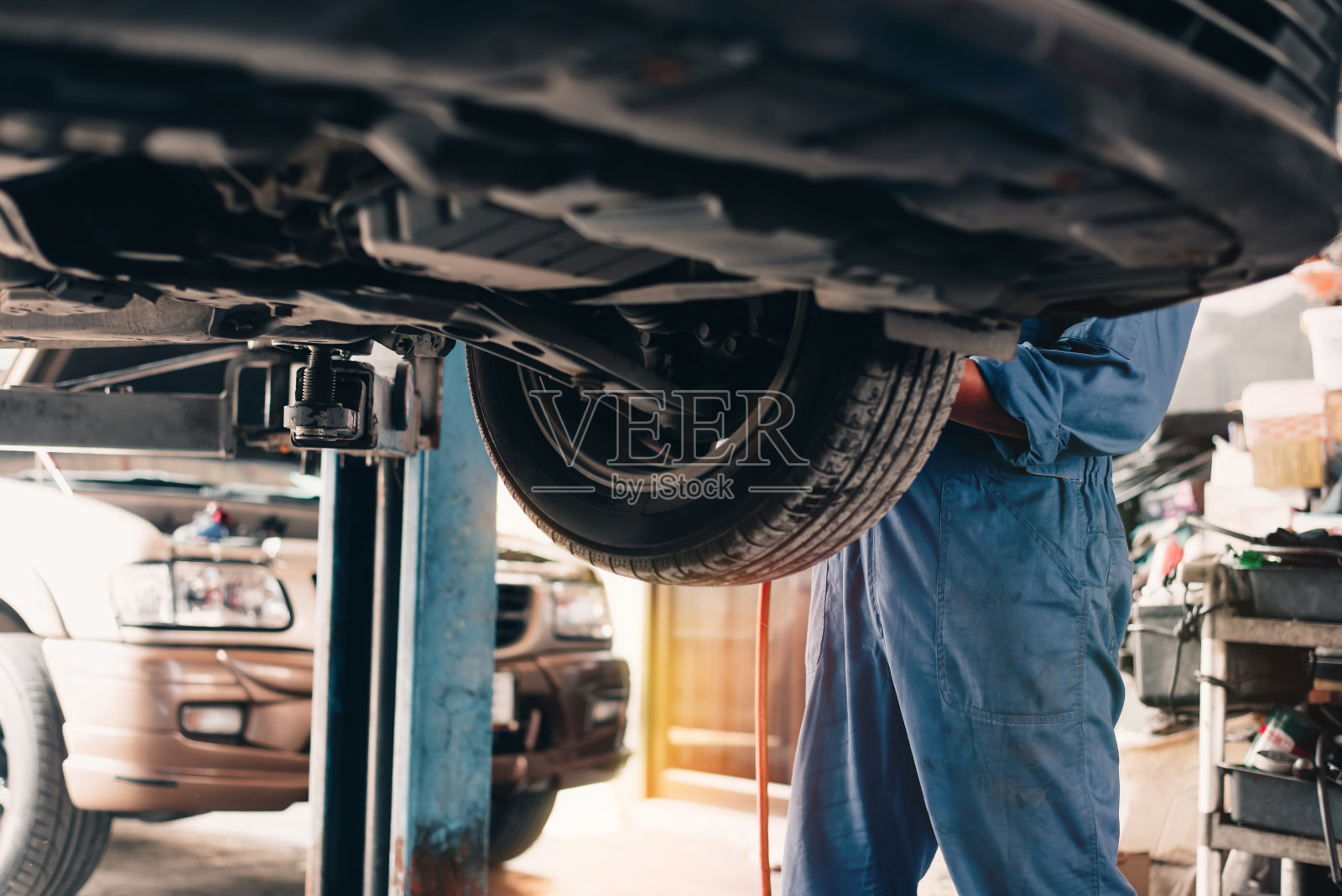 汽车机械师修理汽车悬架，更换备件，计算汽车的里程，并提供维护服务。照片摄影图片