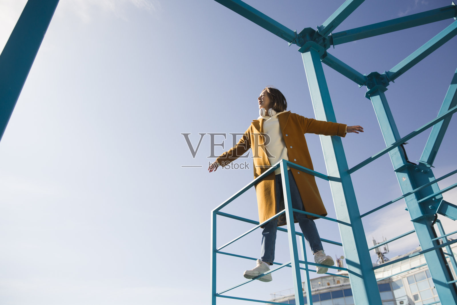 一个穿黄色外套的女人在城市里散步。副本的空间。照片摄影图片