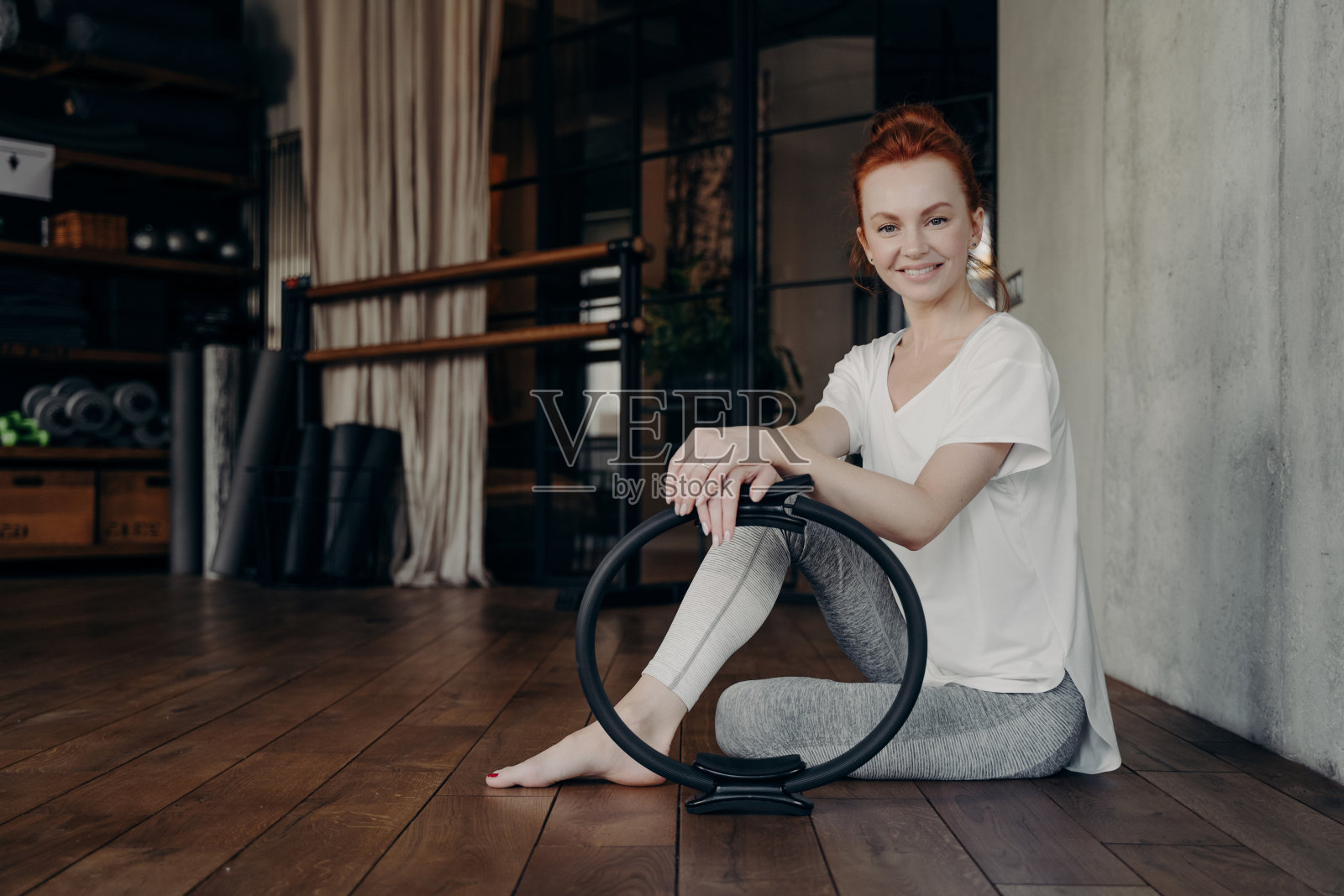 微笑年轻的运动女子与普拉提环享受健身工作室锻炼照片摄影图片