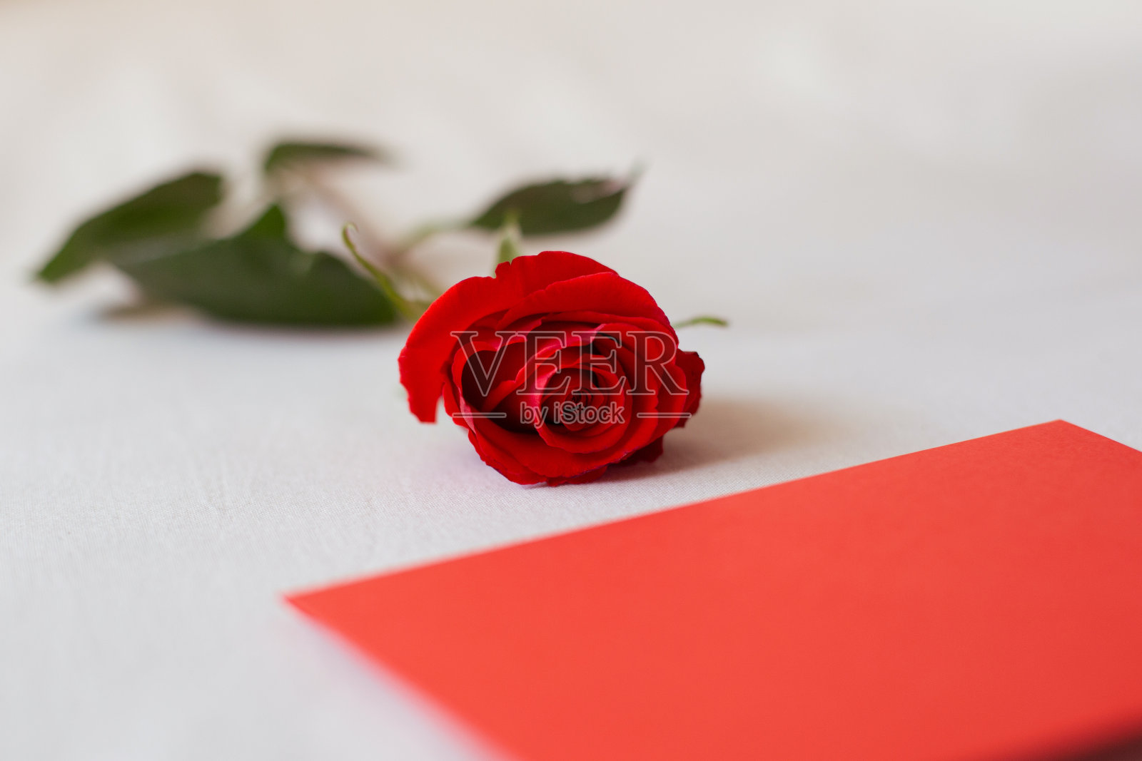 红玫瑰和信封与复制空间在白色床的背景照片摄影图片