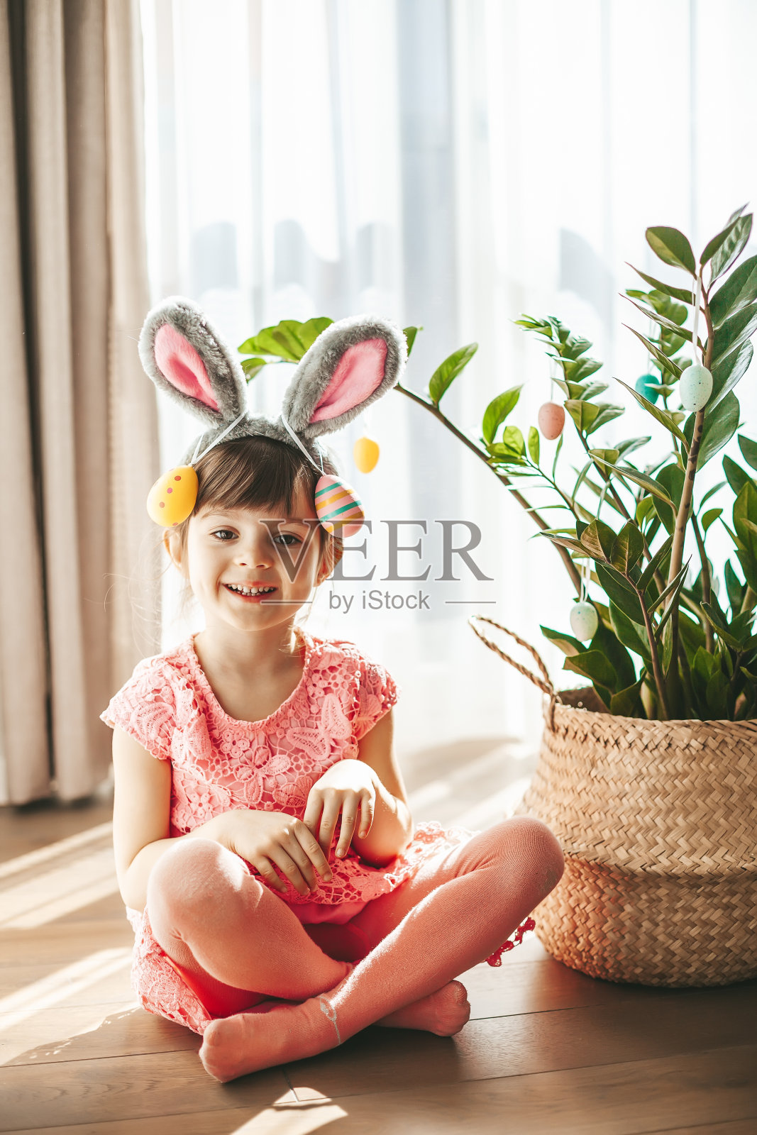 可爱的小女孩，有兔子耳朵和彩绘鸡蛋照片摄影图片