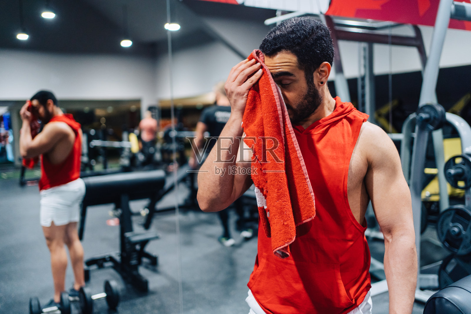 年轻的夫妇正在健身房锻炼。迷人的女人和英俊的肌肉男子正在轻现代健身房训练。做壶铃平板支撑。举重俯卧撑。照片摄影图片