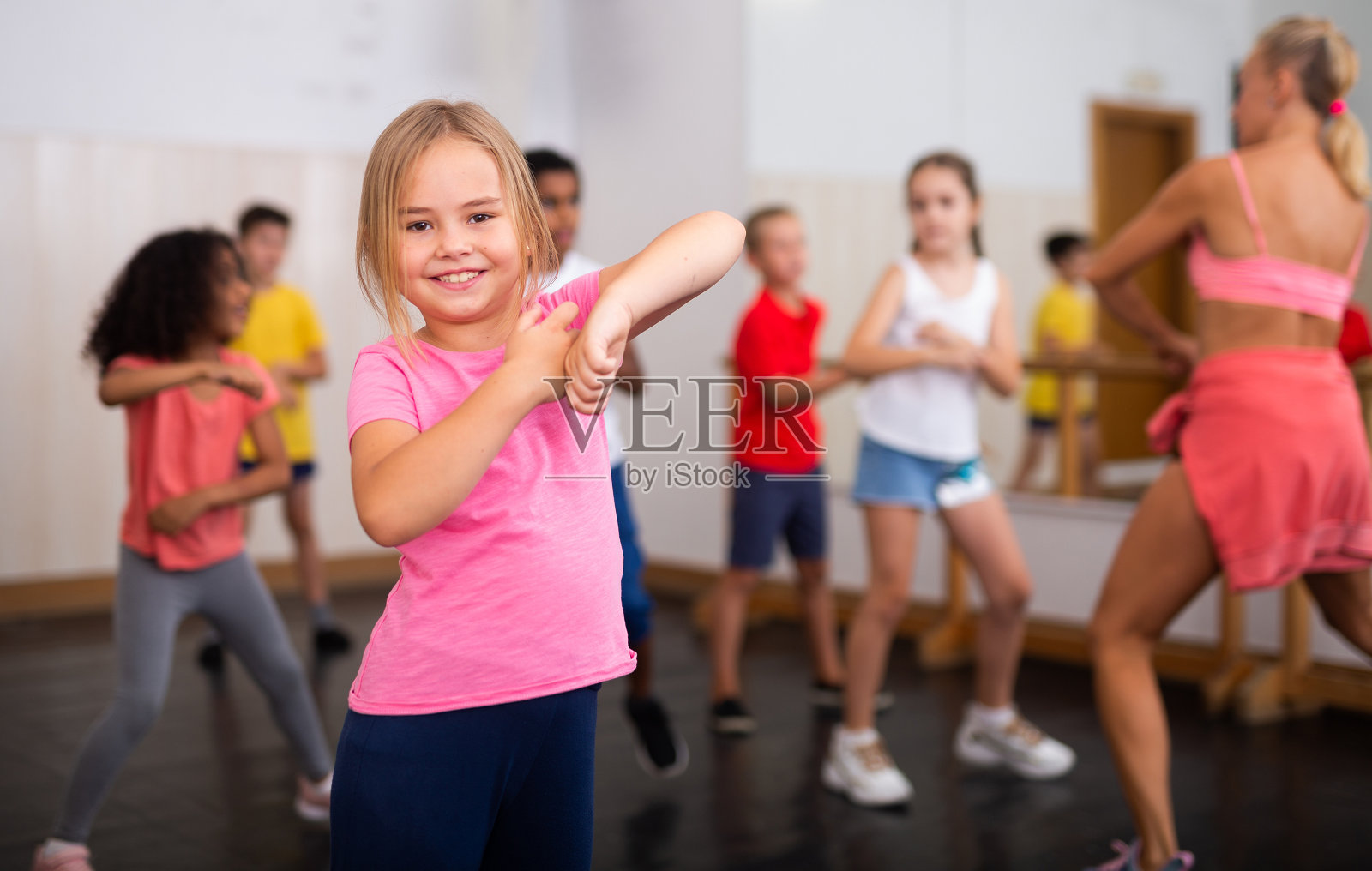 十几岁前的女孩和一群孩子练习舞蹈动作照片摄影图片