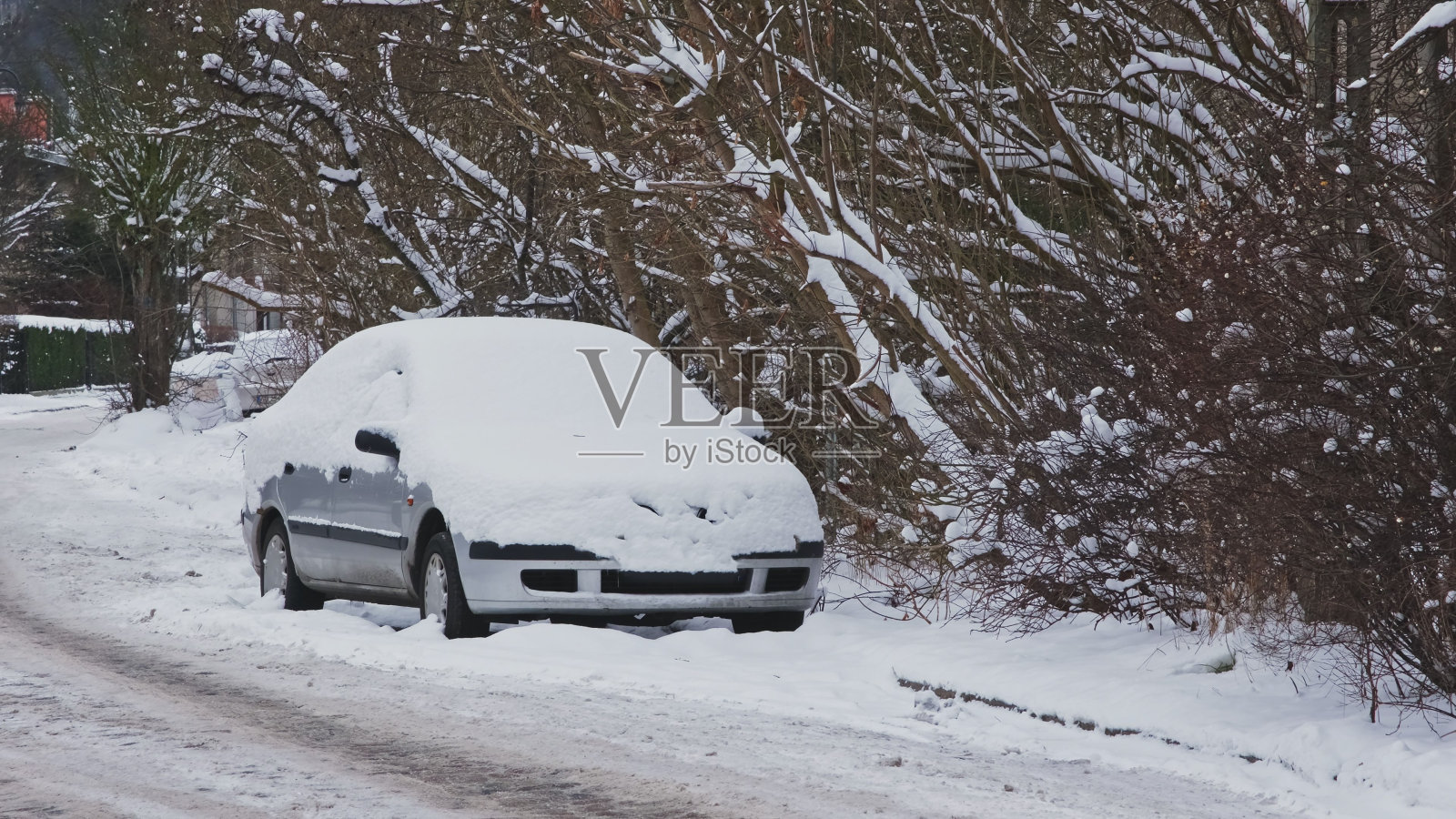 暴风雪过后，停在路边的汽车覆盖着新鲜的白雪照片摄影图片