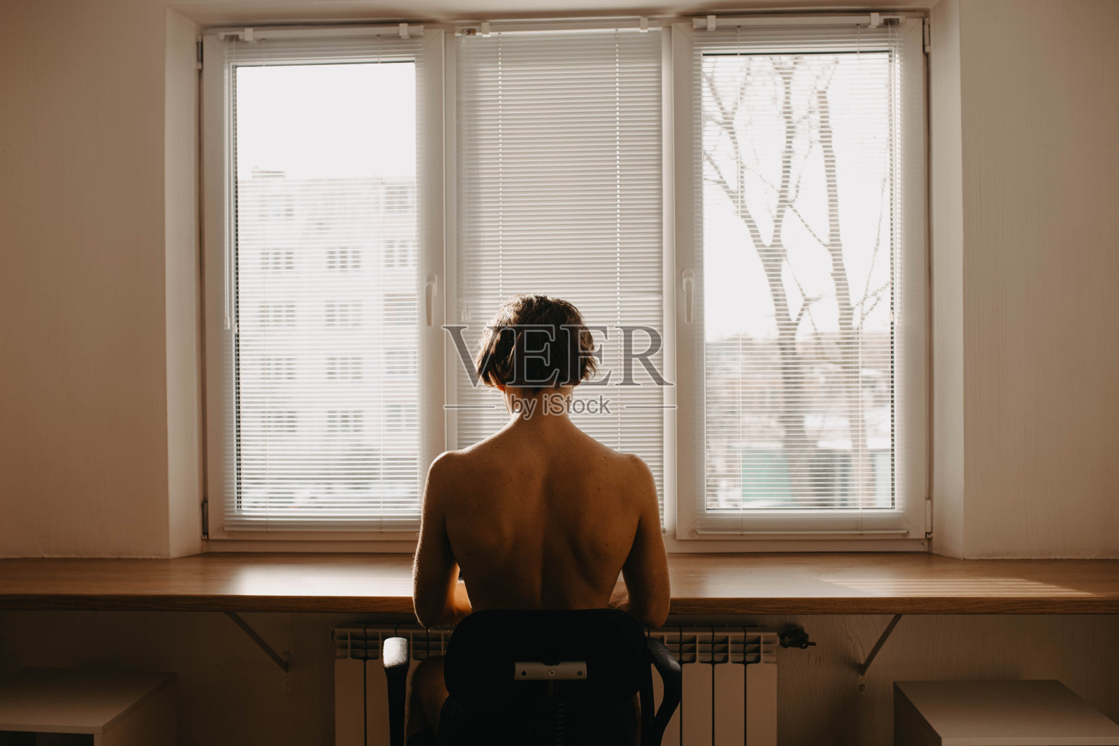 男人与一个的躯干在家里在工作地点窗台桌子在家里工作。照片摄影图片