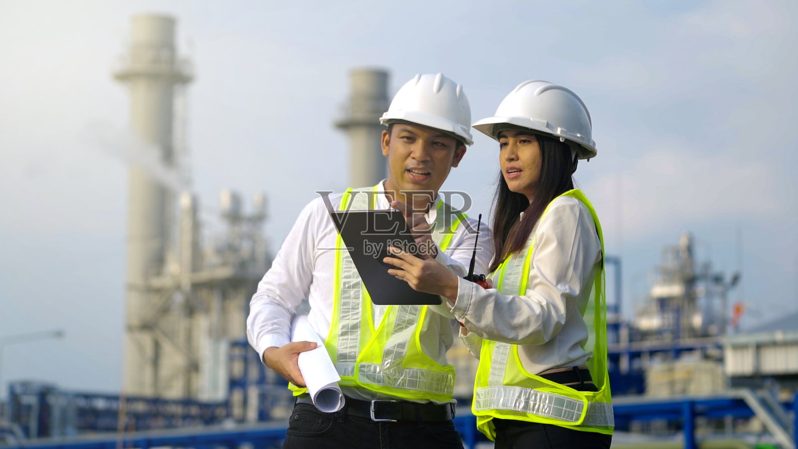 两个在发电厂附近工作的工业工程师。照片摄影图片