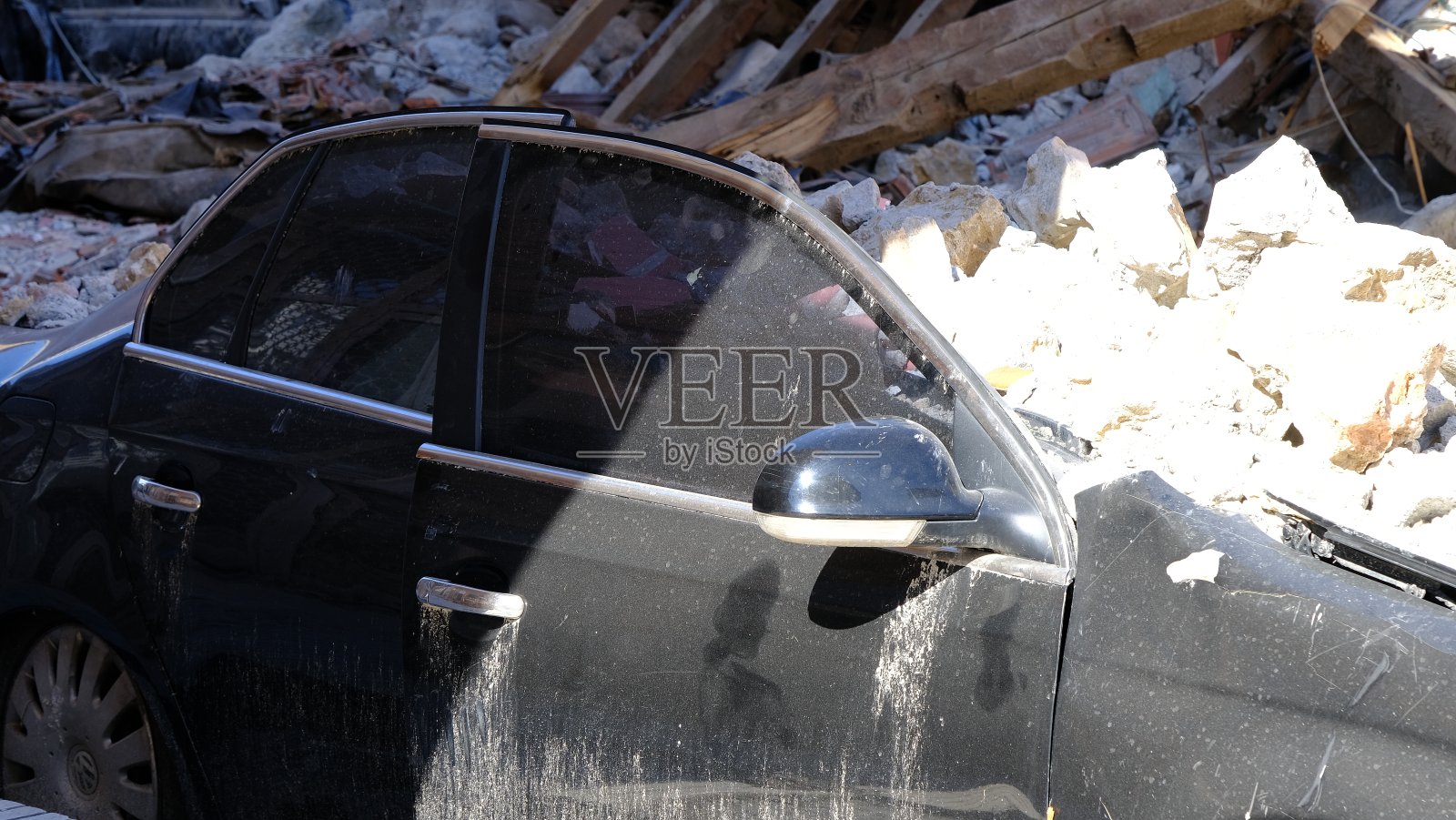 在土耳其发生的7.7级地震中，被压在倒塌建筑物下的汽车被严重损坏。照片摄影图片