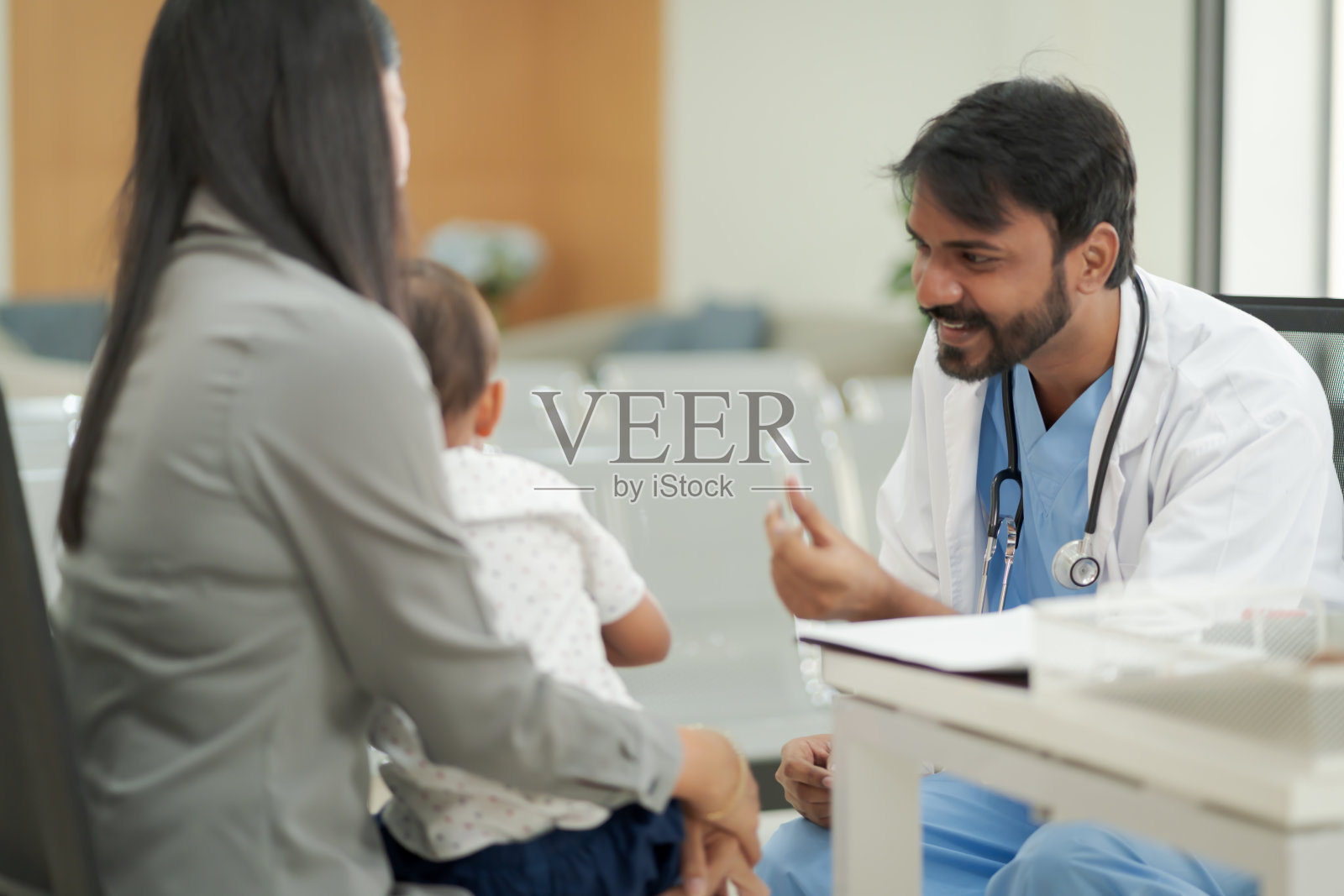 治疗儿科病人的好医生。孩子和他的家人带他去医院看医生，因为他病了。照片摄影图片