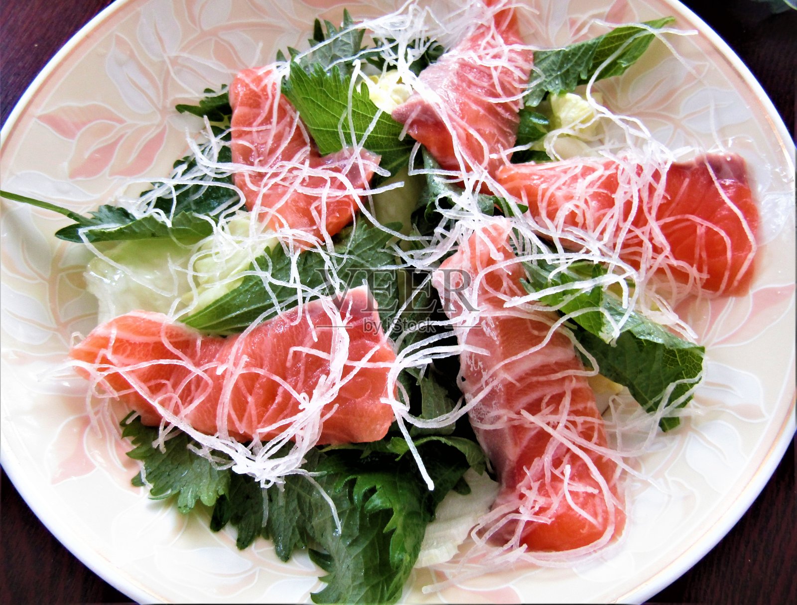 用生鲑鱼、生菜、白萝卜和紫苏叶做成的沙拉。照片摄影图片