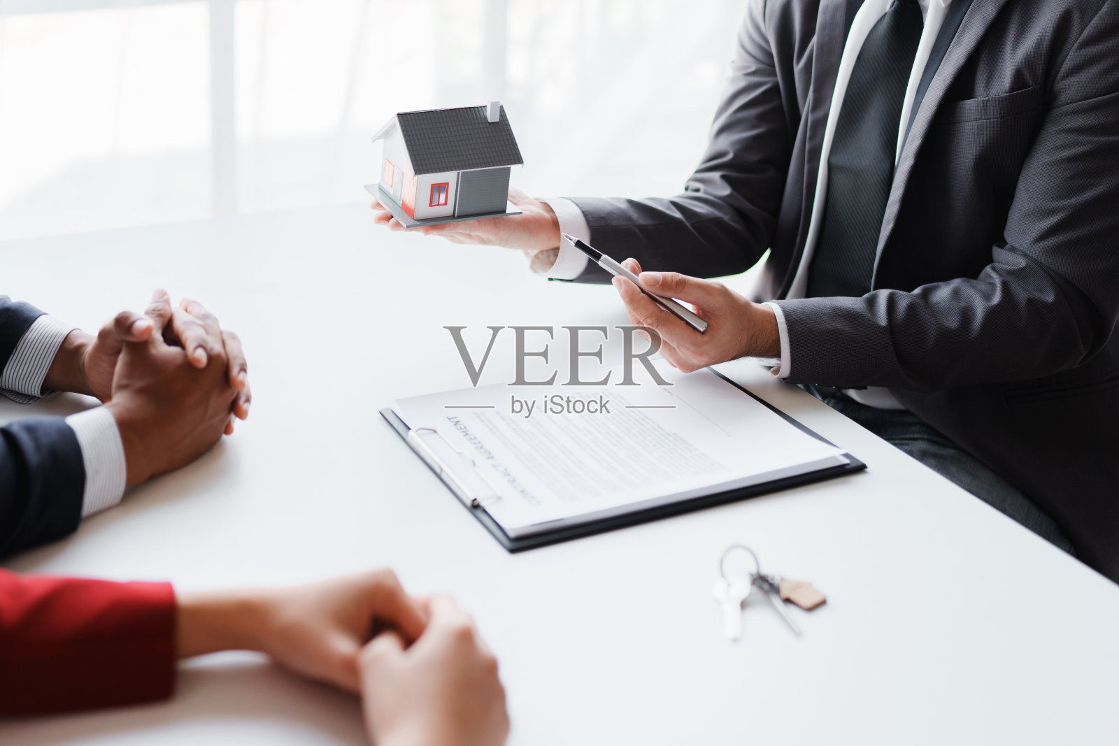 购买住宅和土地的房地产公司在出售房屋并签订贷款协议后，将钥匙和住宅转交给夫妇。照片摄影图片