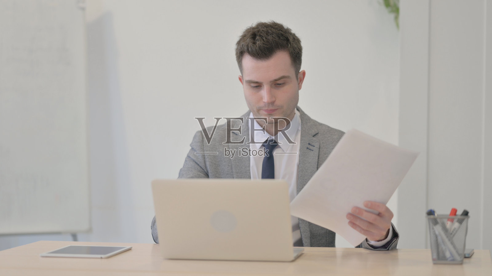 年轻的商人在笔记本电脑和文件工作照片摄影图片