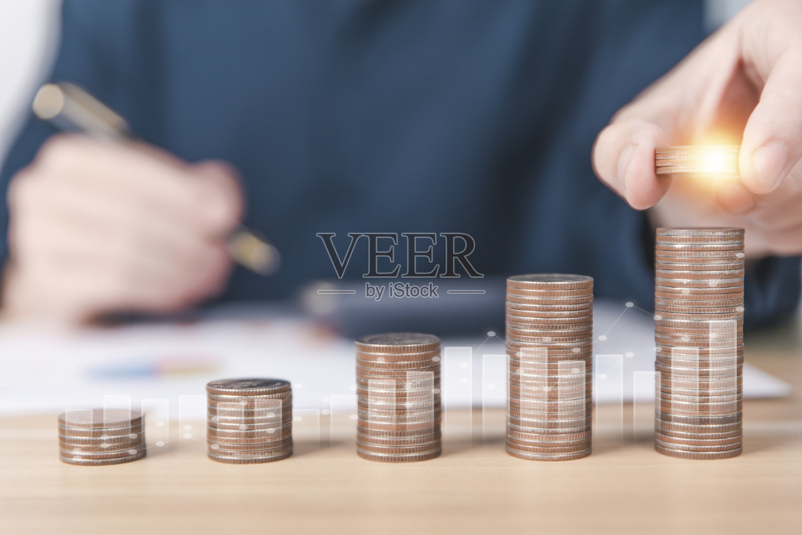 男人攒钱，把硬币放在硬币里，更重叠和显示金融图表，银行照片摄影图片