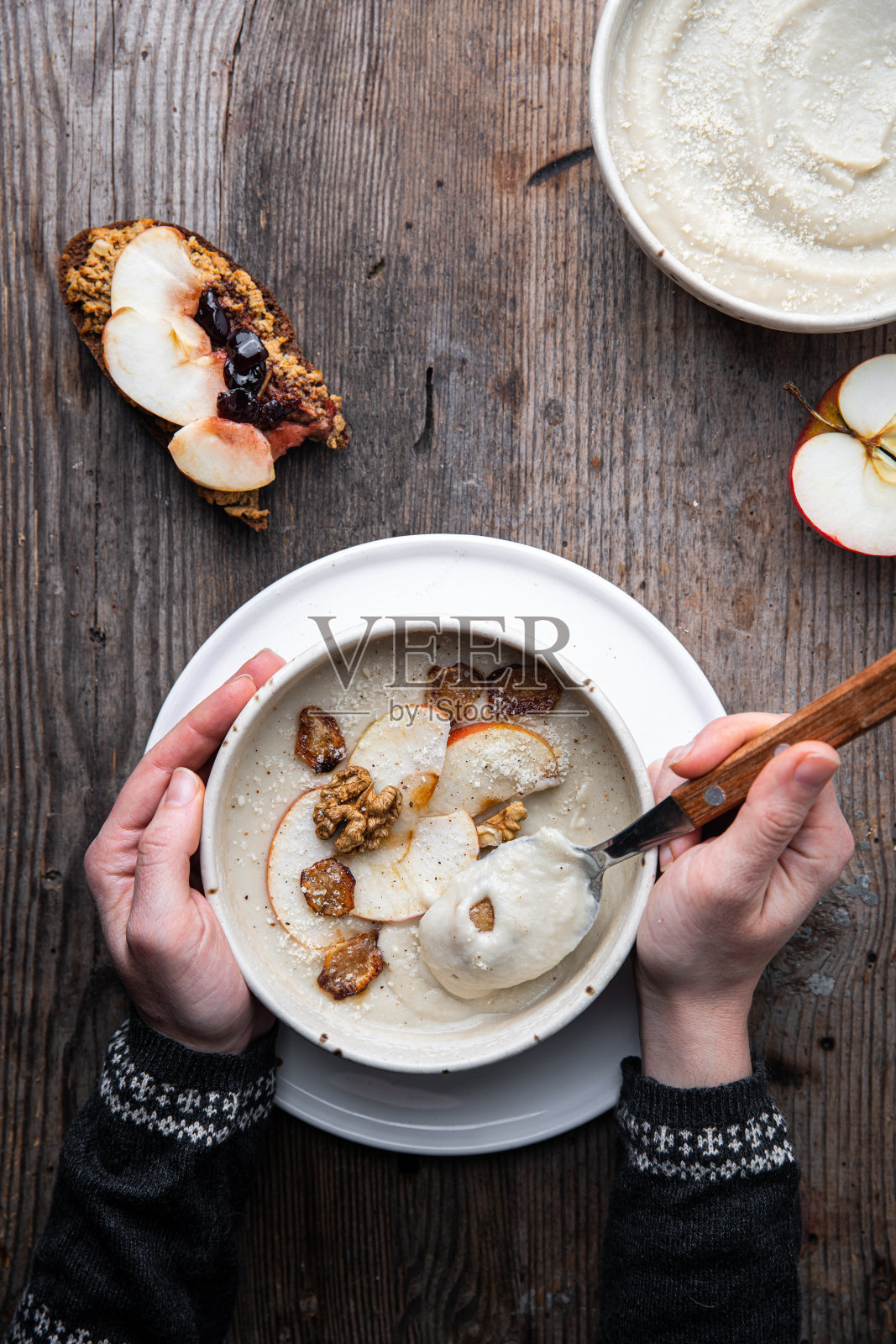 女人吃着耶路撒冷洋蓟和苹果奶油汤和三明治。照片摄影图片