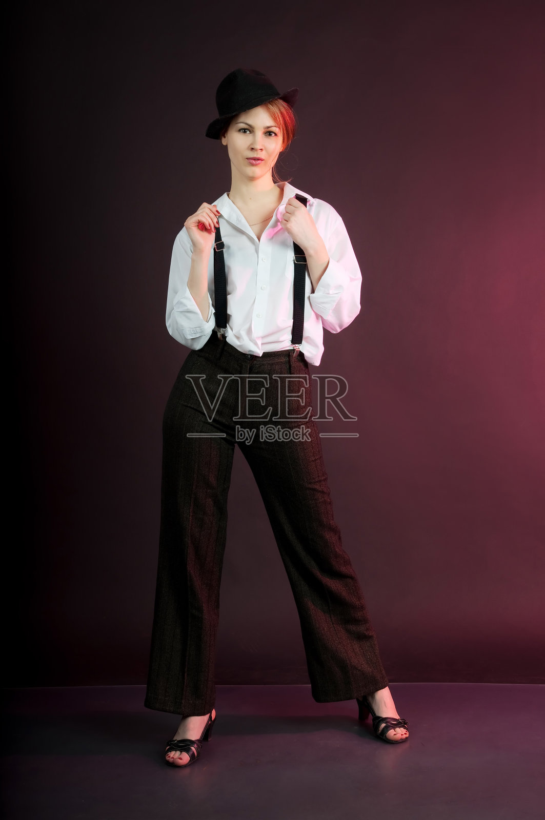 女人穿着条纹裤和白衬衫，背带裤。照片摄影图片