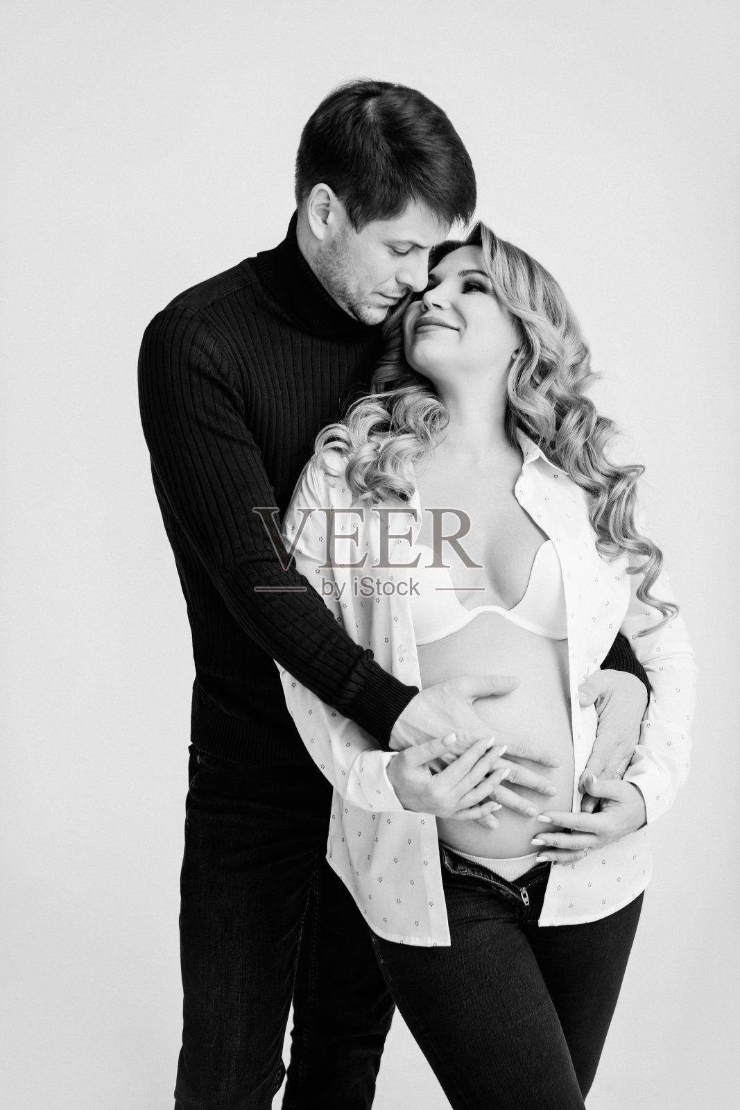 一个金发孕妇与一个穿黑白衣服的男人拥抱照片摄影图片