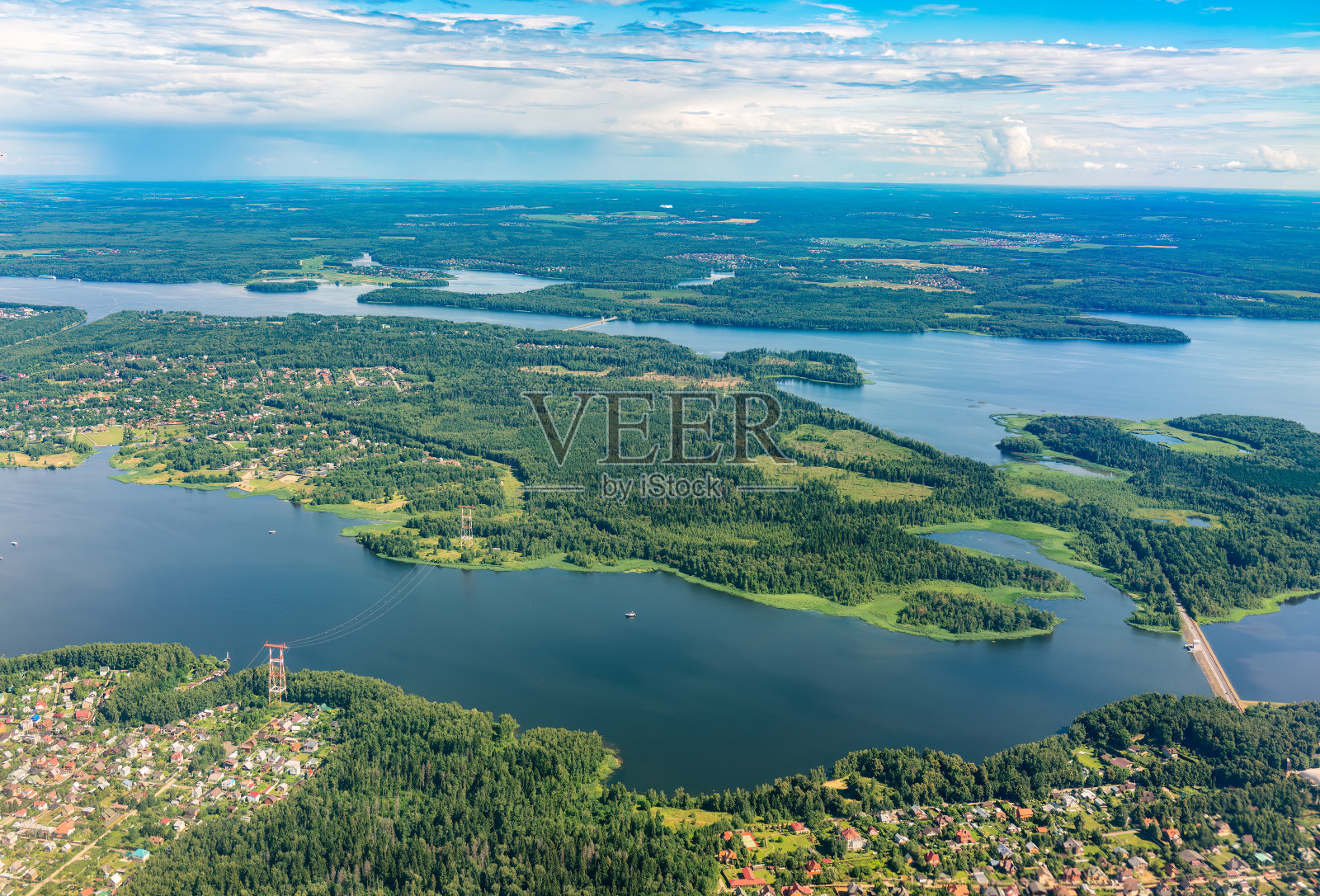 在着陆时，从飞机窗口俯瞰绿色地面和河流。飞机窗口视图。照片摄影图片
