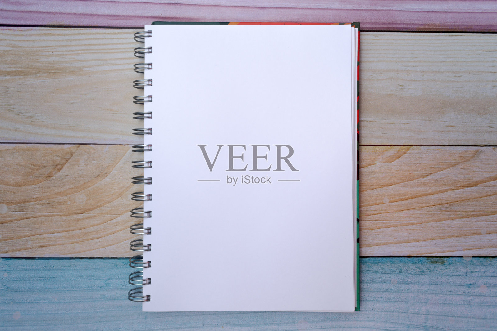 顶部视图的一个彩色马德拉斯背景上一个普通的白色记事本照片摄影图片