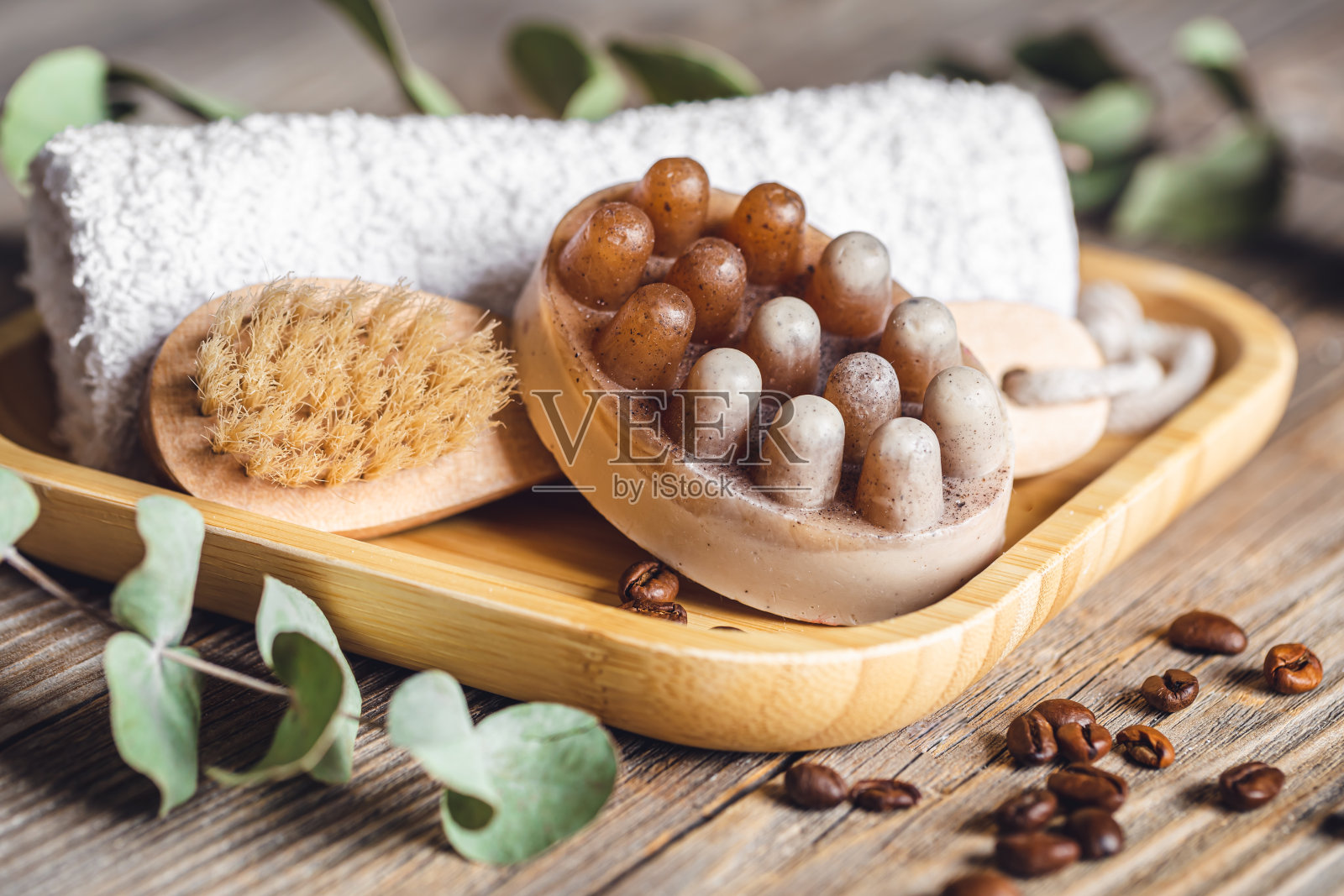 温泉成分与咖啡按摩磨砂皂在木质表面。照片摄影图片