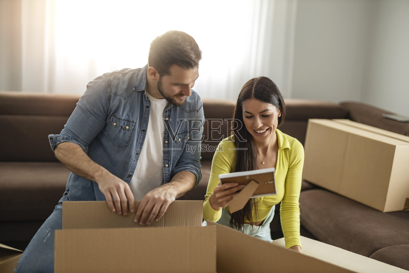 微笑的夫妇在新家里拆箱子照片摄影图片