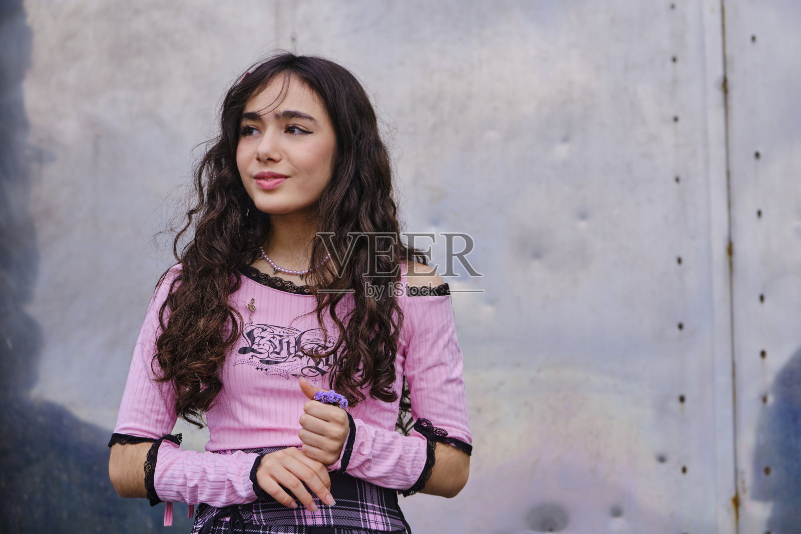 十几岁的女孩穿着哥特风格，站在一扇金属门前摆姿势照片摄影图片