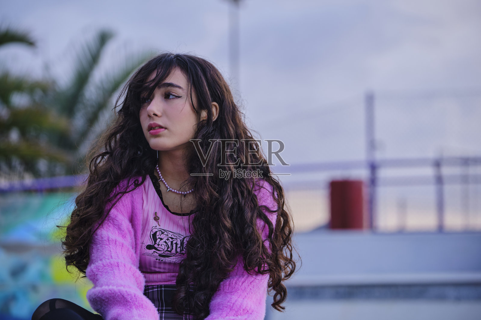 一个十几岁的女孩穿着哥特式风格的肖像在滑板公园摆姿势。照片摄影图片