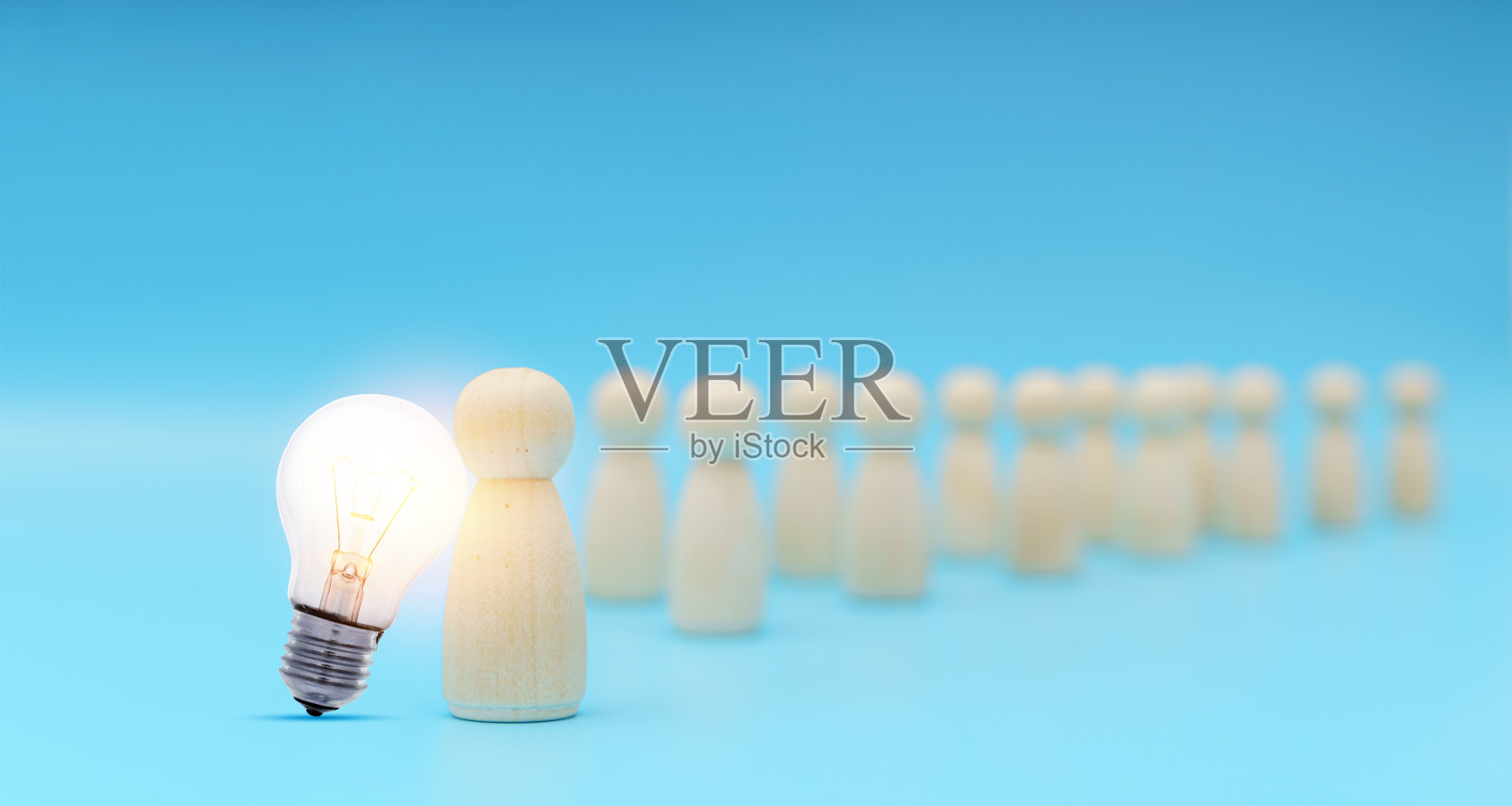 优秀的人站在灯泡图标从人群中脱颖而出。人力资源，人才管理照片摄影图片