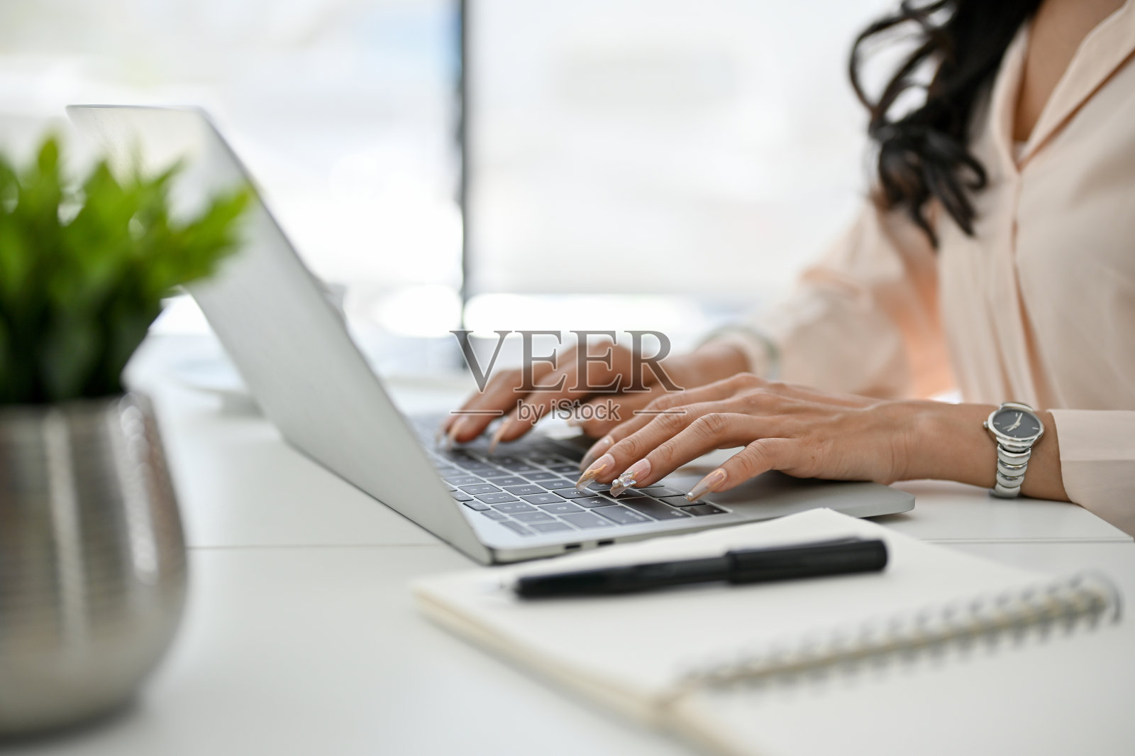 裁剪图像的亚洲女商人使用笔记本电脑，在她的办公室工作。侧视图照片摄影图片