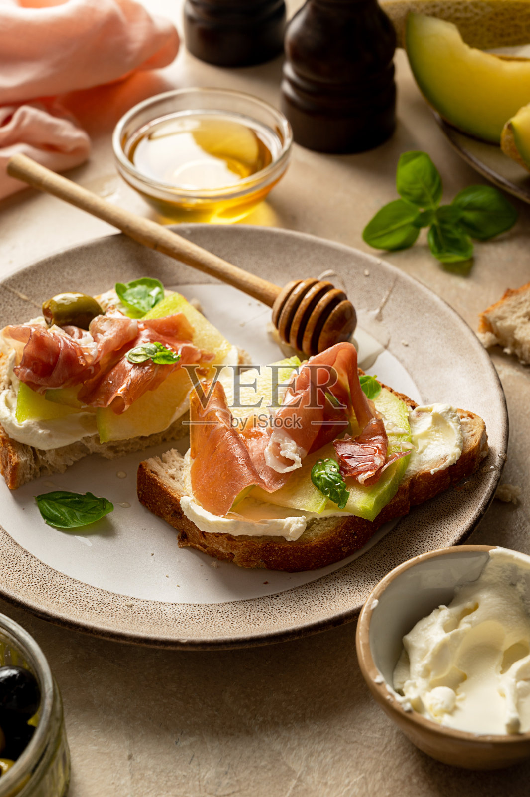 甜瓜熏火腿吐司罗勒和蜂蜜。开胃小菜点心。照片摄影图片