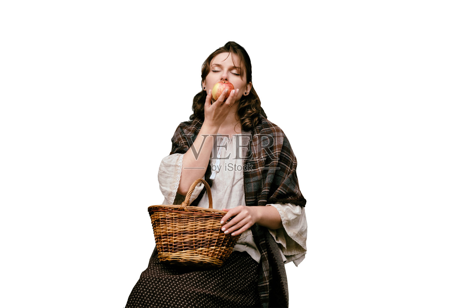 一个年轻女子手里拿着一个苹果，坐在一座古老教堂的窗前，孤零零地躺在白色的背景上照片摄影图片